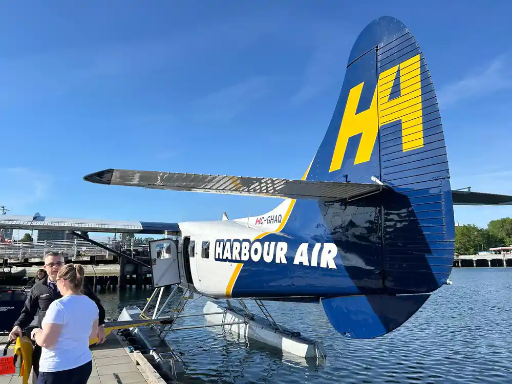The blue and yellow tail of a Harbour Air aircraft at the dock