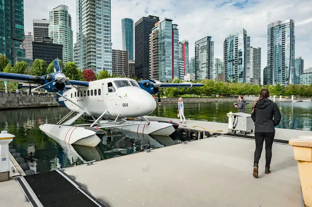 A floatplane at the Vancouver dock with the downtown towers behind it
