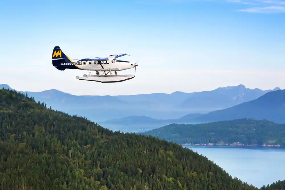 A Harbour Air Otter in flight above a forested coastline