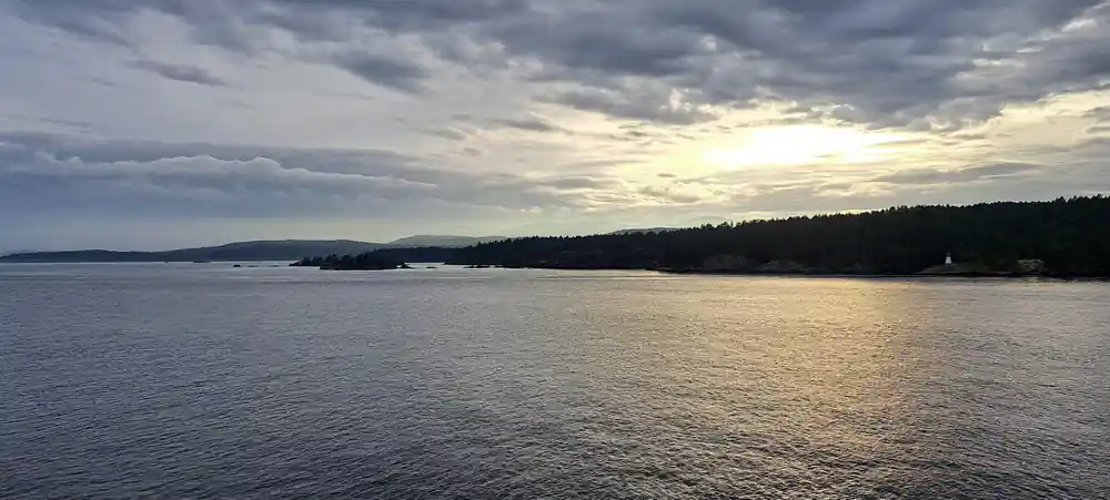 Low islands and open water under a bank of evening cloud