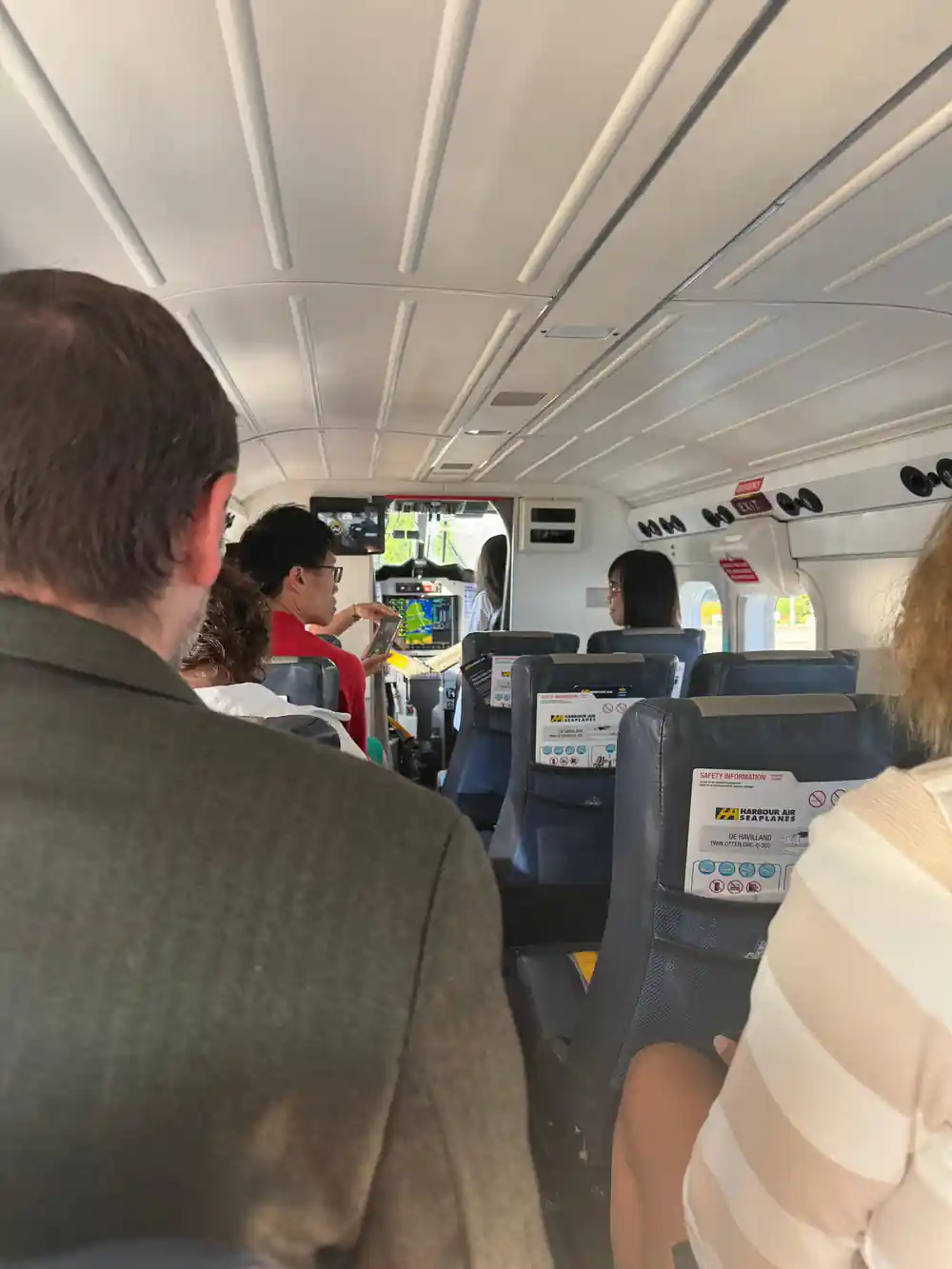 The narrow cabin from behind, passengers in single seats