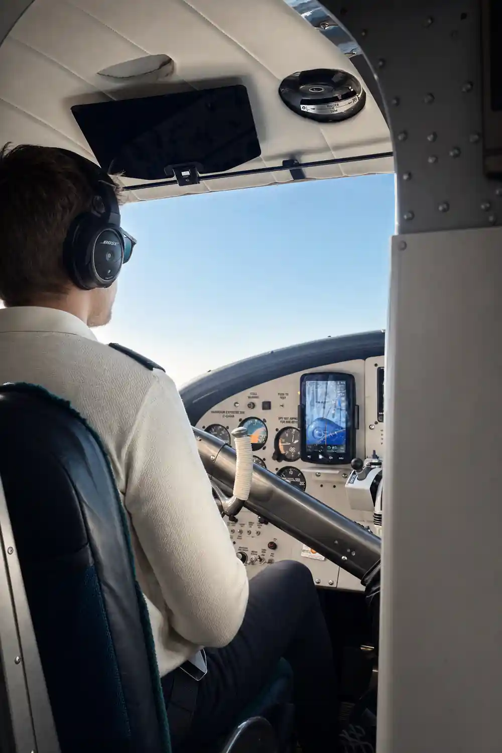 The pilot at the controls with the instrument panel ahead