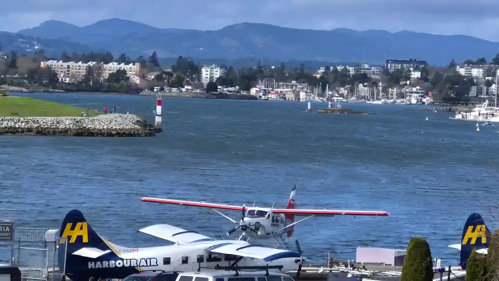 A red and white floatplane at the dock with the town behind