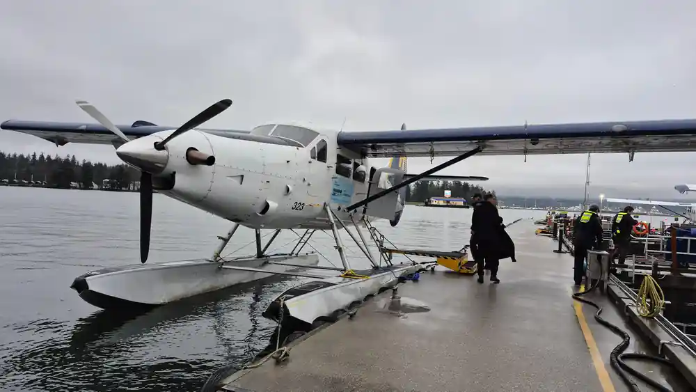 A single-engine floatplane on the dock, propeller still