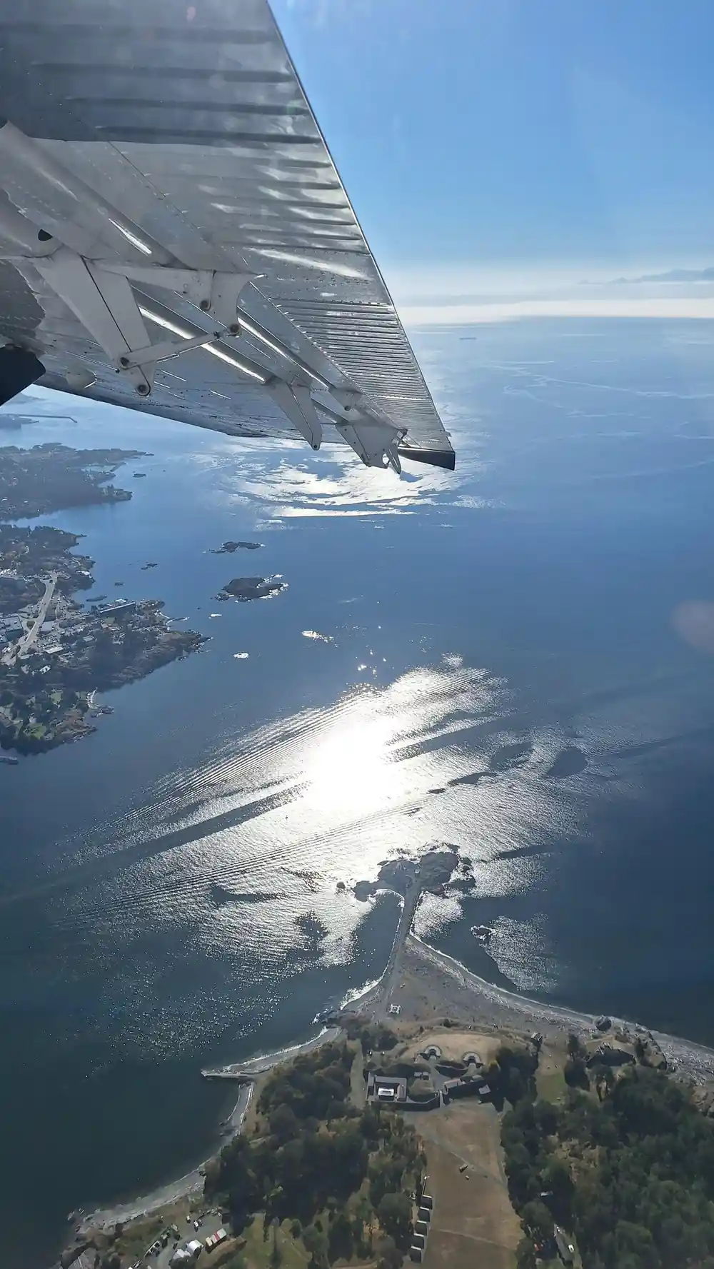 Sun on the water below the wing, islands scattered in it